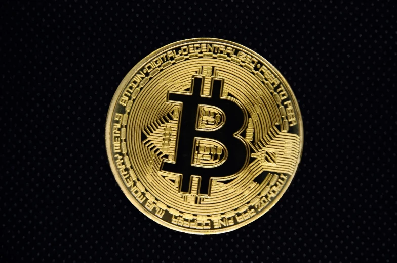 a gold bitcoin on a black background, baroque, detailed product photo