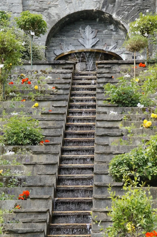 a set of stone steps leading up to a water fountain, by Hans Fischer, flowers rain everywhere, high quality image”