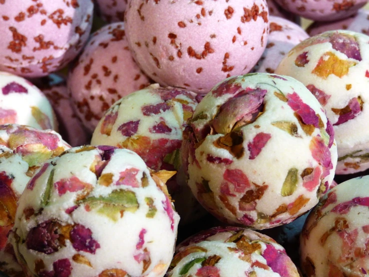 a pile of bath bombs sitting on top of a table, by Charlotte Harding, rose petals, detailed zoom photo, “berries, paisley