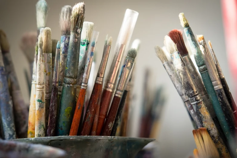 a close up of a bunch of paint brushes, a photorealistic painting, inspired by artist, pexels, beautiful art uhd 4 k, andrey gordeev, artistic angle, easel