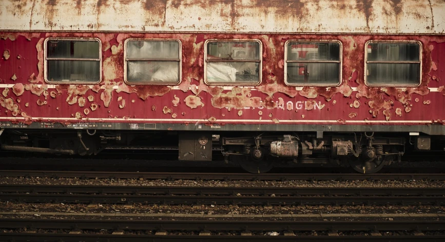 a close up of a train on a train track, a portrait, by Richard Carline, flickr, graffiti, dull red flaking paint, budapest, reportage photo, h. r geiger