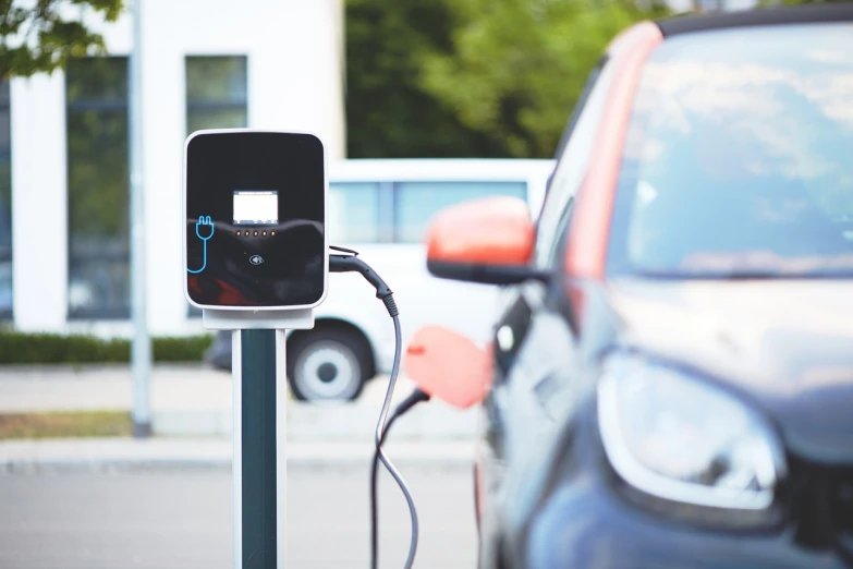 a close up of a parking meter with a car in the background, shutterstock, les automatistes, electric energy, avatar image, cable plugged in, 🦩🪐🐞👩🏻🦳