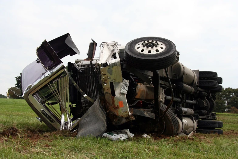 a truck that is sitting in the grass, by Paul Davis, shutterstock, crashed in the ground, above side view, collapsed water tower, stock photo