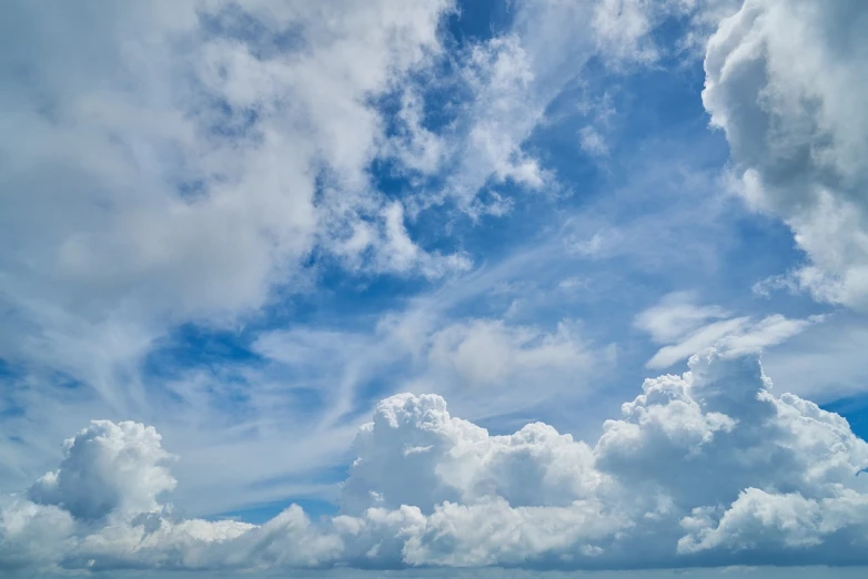 a group of people standing on top of a beach under a cloudy sky, a stock photo, shutterstock, minimalism, beautiful sky with cumulus couds, view from below, beautifull puffy clouds. anime, flying above the clouds