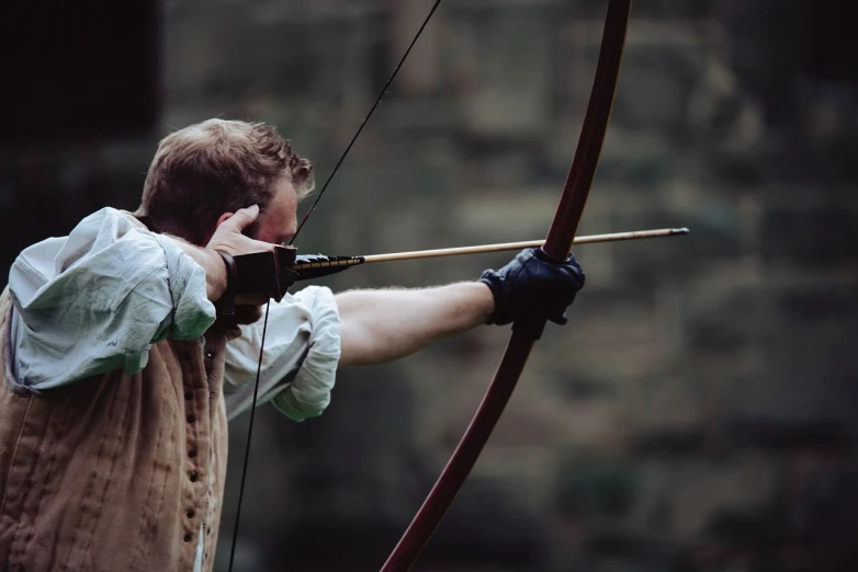 a man that is holding a bow and arrow, by Edward Corbett, pexels, robin hood, stock photo, concentration, 1 4 9 3