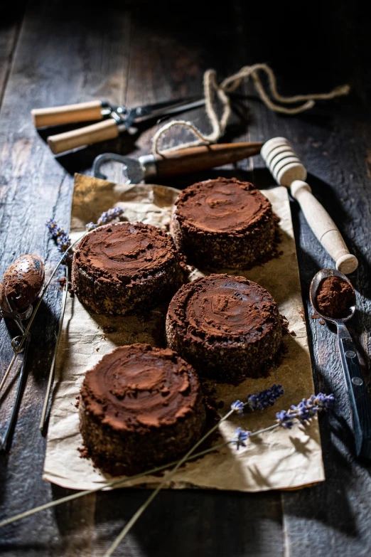 a table topped with brownies covered in chocolate frosting, antipodeans, rustic, circle, bee, 35 mm product photo”