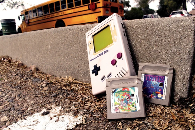 a nintendo game boy next to a school bus, by Douglas Shuler, high res, stained”, phot, leaked