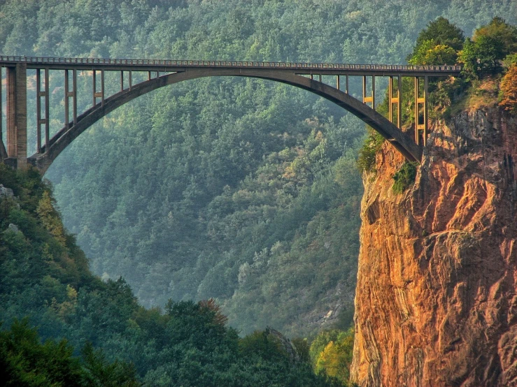 a train that is going over a bridge, by Franz Hegi, pexels contest winner, renaissance, in between a gorge, summer morning, ukraine. photography, panorama