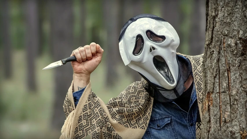 a man in a white mask holding a knife, a picture, inspired by Clark Voorhees, shutterstock, outdoor photo, scream, movie still 8 k, comedy