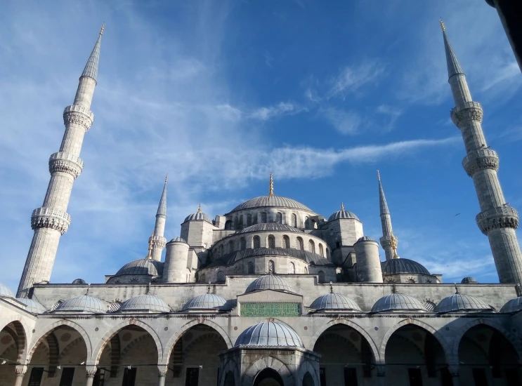 a large white building with a blue sky in the background, a picture, inspired by Altoon Sultan, flickr, hurufiyya, tall stone spires, circular, blue gray, as far as the eye can see