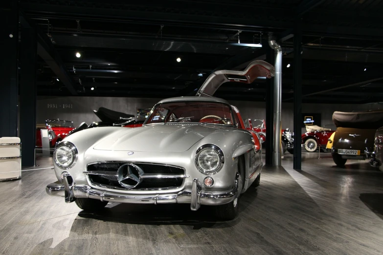 a silver mercedes sports car on display in a museum, by Gawen Hamilton, silo, las vegas, boston, dark classic interior