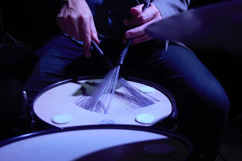 a person holding a whisk on top of a drum, flickr, purism, drum pads, illuminating the area, holding brush, really close - up shot