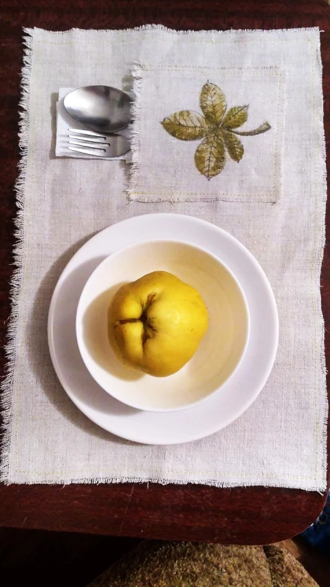 a bowl of fruit sitting on top of a table, a still life, inspired by Weiwei, dau-al-set, cozy calm! fabrics textiles, white and yellow scheme, place setting, iphone photo