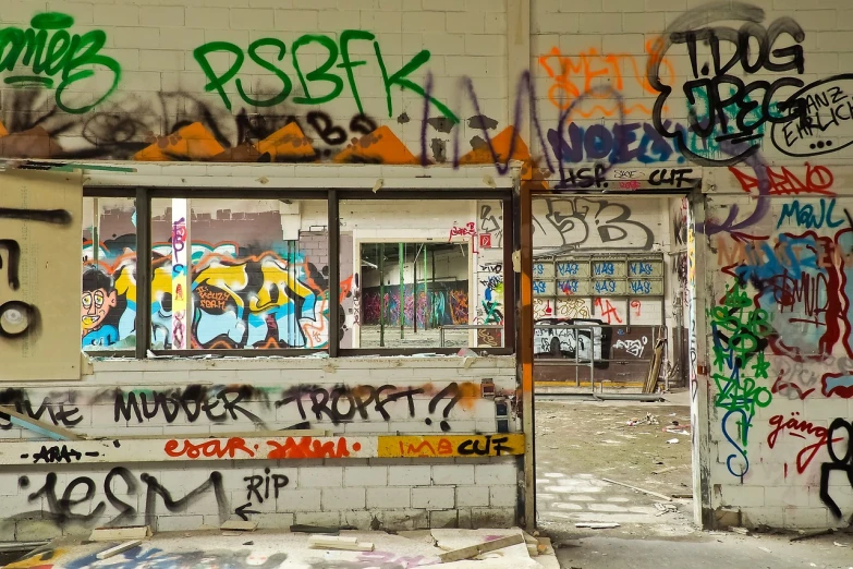 a bunch of graffiti on the side of a building, by Arnie Swekel, flickr, inside a decaying hospital room, doors, factory floor, looking out