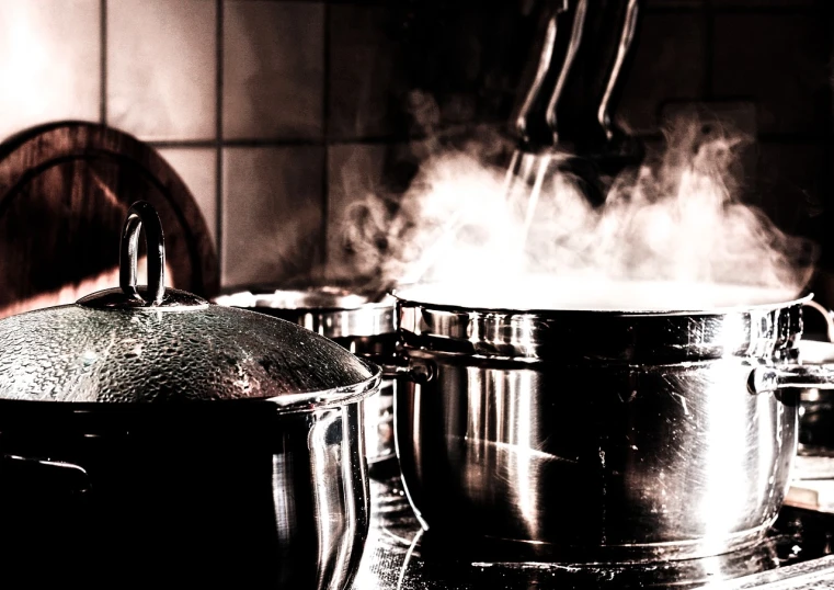 a couple of pots sitting on top of a stove, a stock photo, by Mirko Rački, pexels, process art, steaming food on the stove, dramatic lighting !n-9, shiny silver, banner