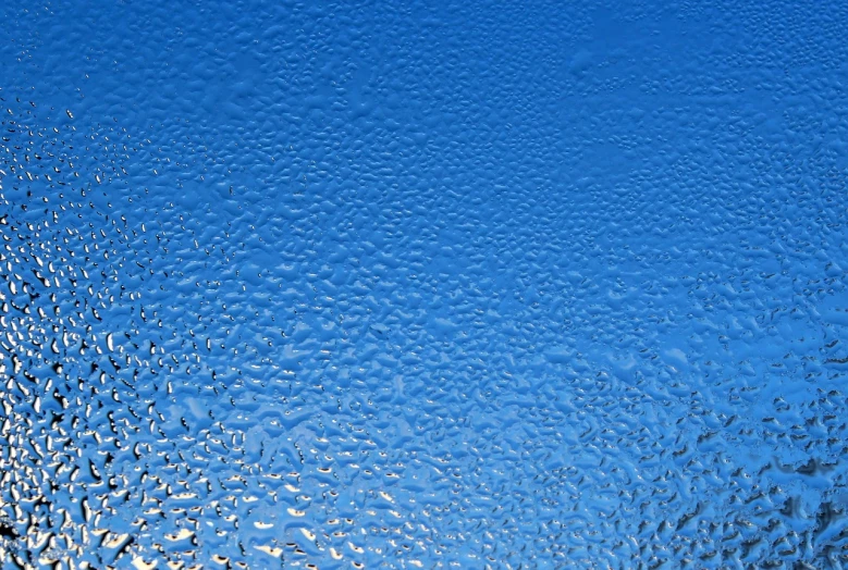 a close up of a frosty window with a blue sky in the background, a detailed painting, minimalism, ultra detailed rain drops, highly realistic bump map, rippling reflections, high angle close up shot