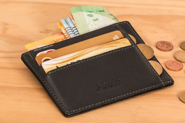 a wallet sitting on top of a wooden table, an illustration of, by Adam Manyoki, shutterstock, cards, pockets, nmm, dubai