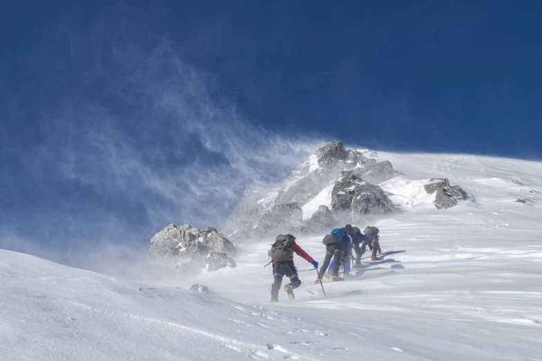 a group of people riding skis down a snow covered slope, by Werner Andermatt, nepal, time to climb the mountain path, blizzard in the mountains, 2 0 2 2 photo