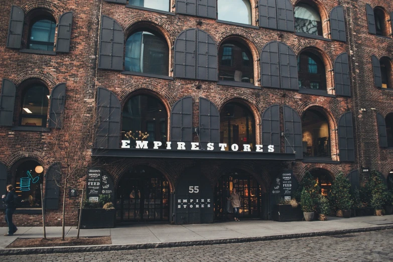 a brick building with a sign that says empire stores, by Emma Andijewska, pexels, ny, great atmosphere, bjarke ingels, lightroom preset