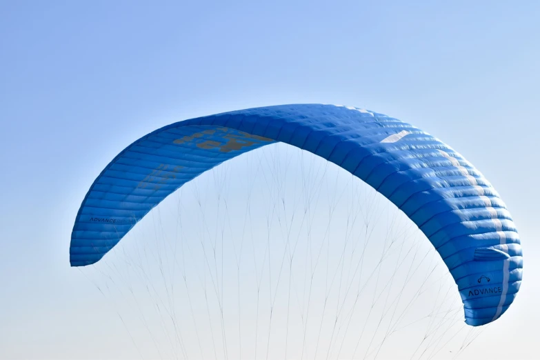 a person parasailing in the sky on a sunny day, a picture, by Julian Allen, shutterstock, rasquache, ornithopter, blue print, back arched, closeup photo