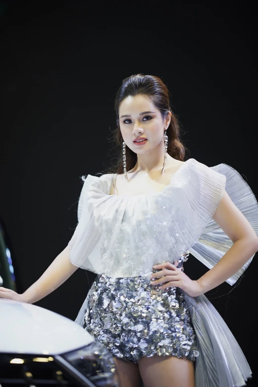 a woman that is standing next to a car, a portrait, by Ruth Jên, shutterstock, wearing silver dress, fashion show photo, korean idol, very beautiful and elegant