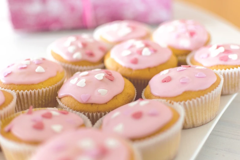 a white plate topped with cupcakes covered in pink frosting, by Jan Kupecký, shutterstock, blurred detail, glazed, healthy, swedish
