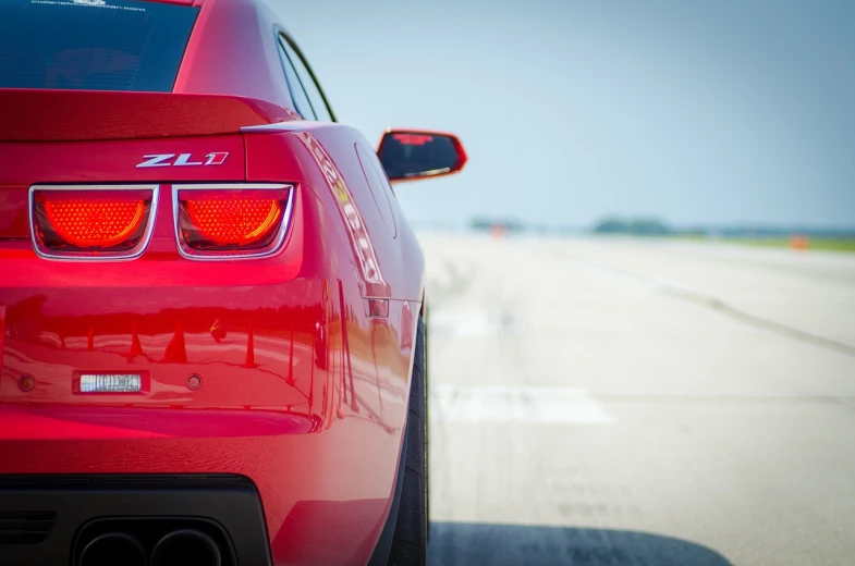 the rear end of a red sports car, by Jason Felix, pexels contest winner, on a racetrack, gm, grain”, short dof