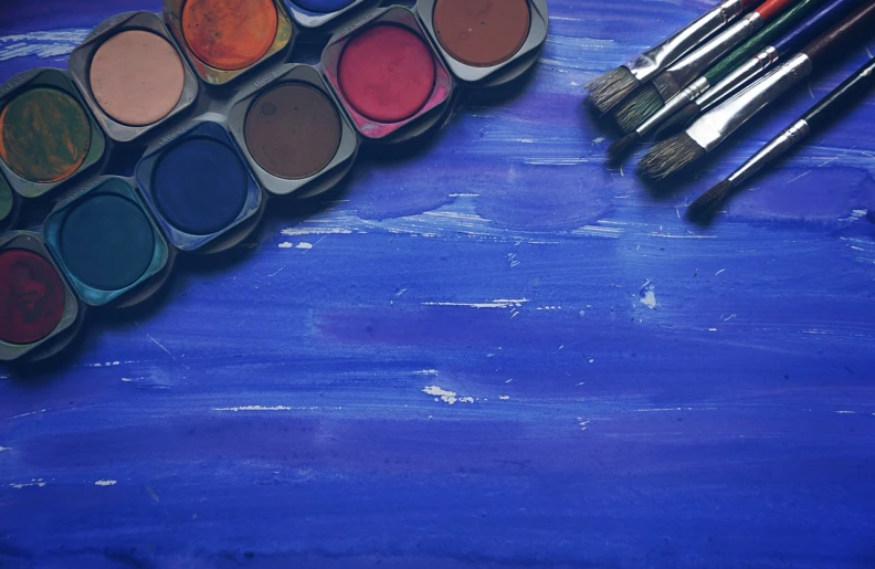 a bunch of paint brushes sitting on top of a blue table, a watercolor painting, metaphysical painting, very beautiful photo, perfect colorful eyeshadows, bright deep blue, viewed from above