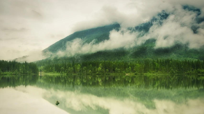 a boat floating on top of a lake next to a forest, a picture, by Alexey Merinov, minimalism, covered in clouds, shades of green, british columbia, silent hill landscape