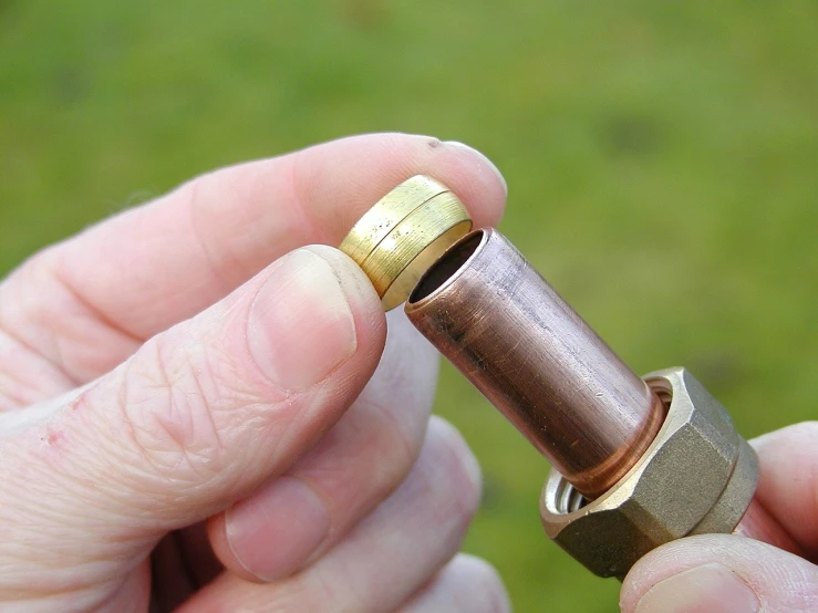 a close up of a person holding a metal object, a macro photograph, by Edward Clark, pixabay, crack pipe, brass and copper, professionally assembled, above side view