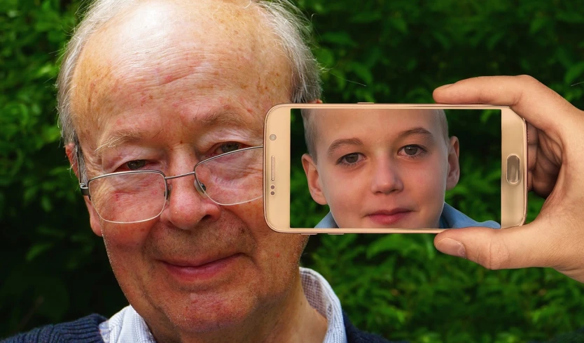 a close up of a person holding a cell phone, a picture, pixabay contest winner, digital art, old and young, accurate klaus schwab face, with a kid, portrait photo of an old man