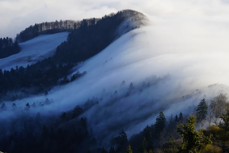 a person standing on top of a snow covered mountain, by Etienne Delessert, flickr, romanticism, blanket of fog, tochigi prefecture, a dragon made of clouds, roofed forest
