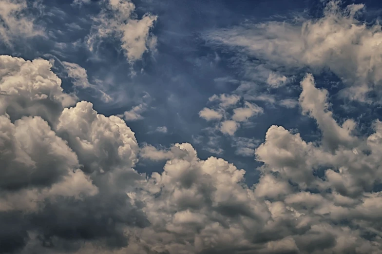 a plane flying through a cloudy blue sky, a picture, by Artur Tarnowski, romanticism, colorful dramatic puffy clouds, in forcasted sky, under a dark cloudy sky, today\'s featured photograph 4k