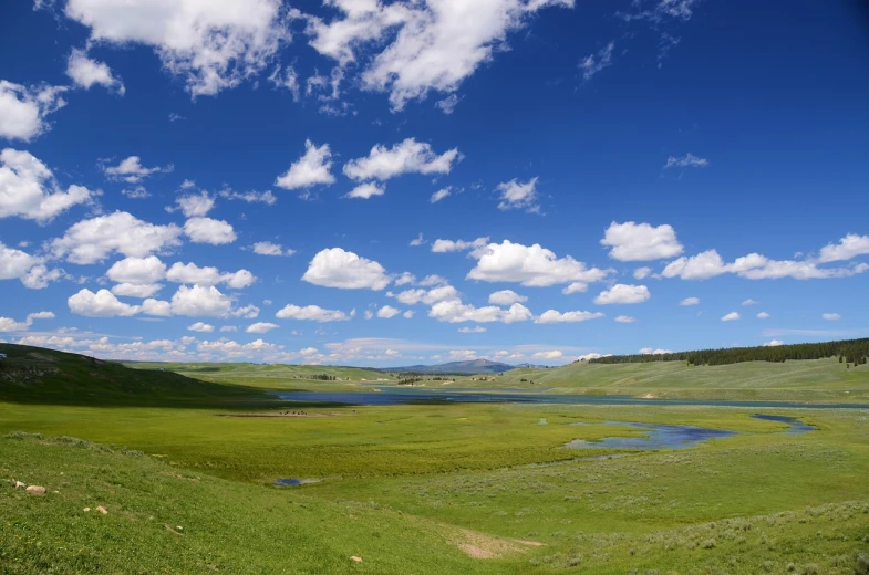 a body of water sitting on top of a lush green hillside, hurufiyya, mongolia, blue sky and white clouds, benjamin vnuk, beijing