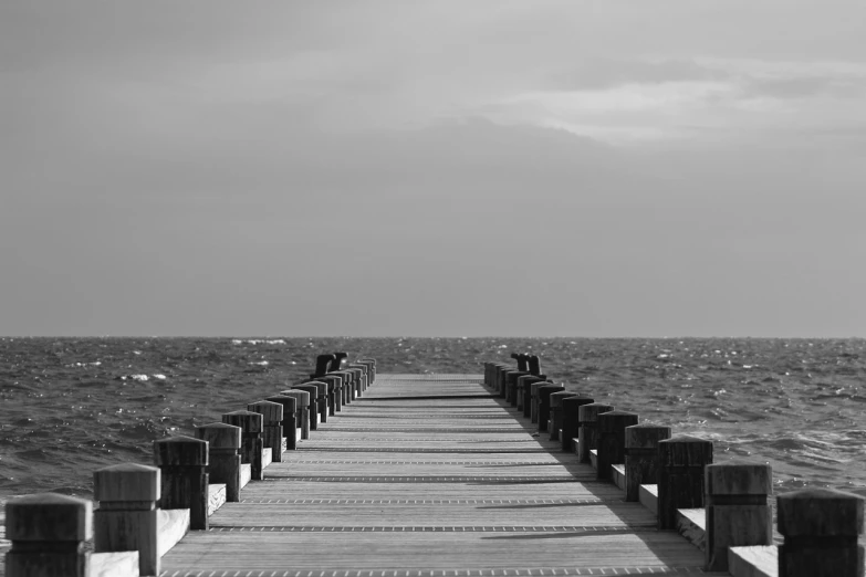 a black and white photo of a pier, a black and white photo, unsplash, nice weather, the infinite, tourist photo, sepia