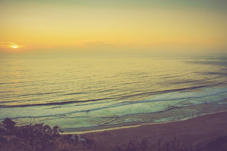 a man riding a surfboard on top of a sandy beach, inspired by Elsa Bleda, romanticism, sweeping vista, faded colors, pch, evening sunset