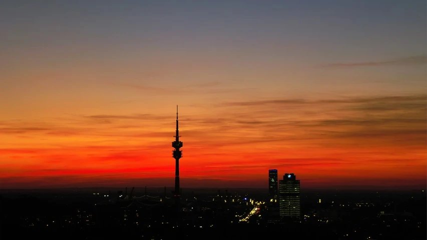 a view of a city at sunset with the television tower in the background, by Werner Gutzeit, pexels contest winner, red and orange glow, shot on kodak vision 200t, hardturm, skyline showing