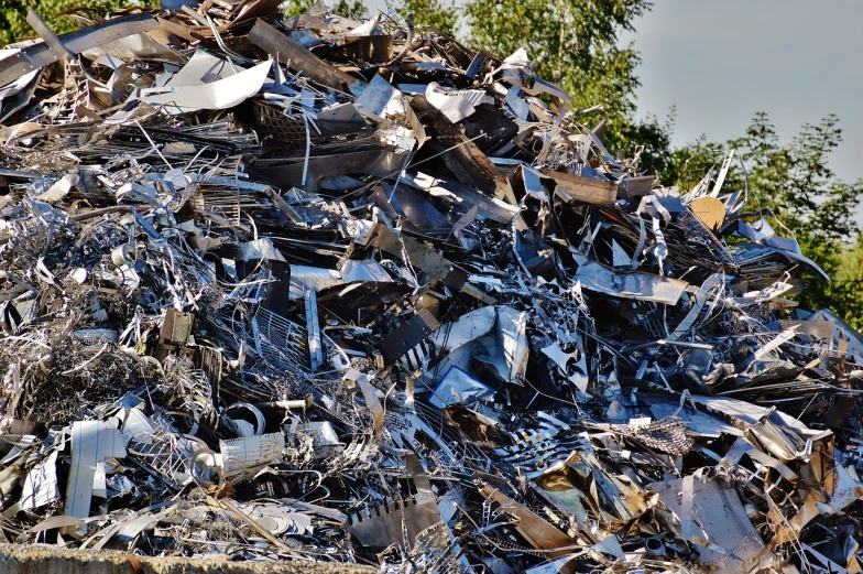 a pile of scrap metal with trees in the background, a photo, shiny silver, high quality product image”