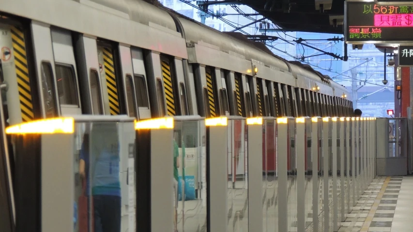 a subway train pulling into a train station, a picture, flickr, figuration libre, yellow lighting from right, bars on the windows, medium detail, vtm