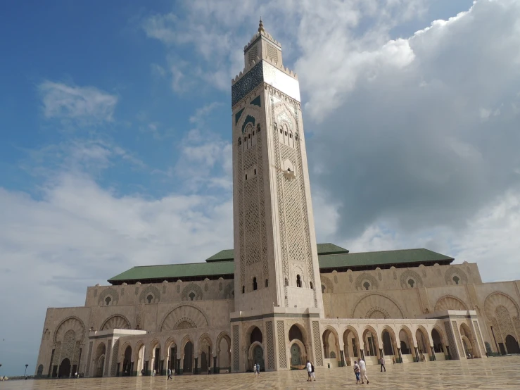 a large white building with a clock tower, inspired by Alberto Morrocco, arabesque, that is 1300 feet tall, moroccan mosque, on a cloudy day, terminal