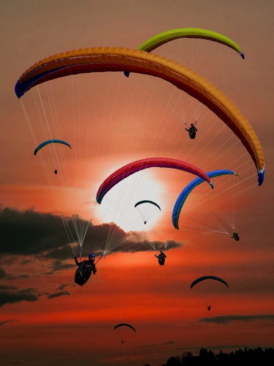 a group of paragliders flying through the air at sunset, a picture, by Andrei Kolkoutine, shutterstock, posterized color, colorful sunset!!, beautiful composition, ny