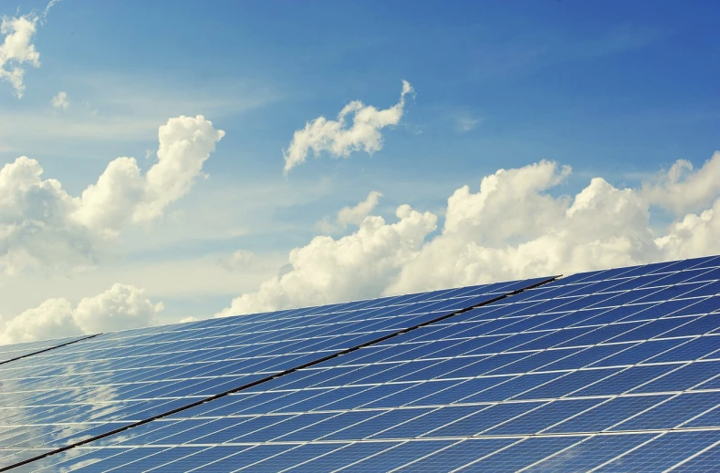 a close up of a solar panel with clouds in the background, a picture, by Carey Morris, pexels, bauhaus, solarpunk cantine, blues, clear and sunny, perfectly shaded