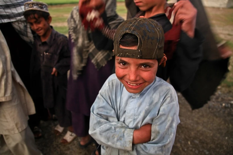 a young boy standing in front of a group of people, flickr, hurufiyya, brutal joyful face expression, chambliss giobbi, cute boys, photograph credit: ap