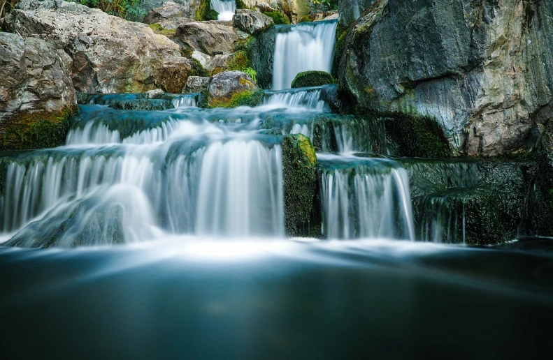 a waterfall in the middle of a lush green forest, a tilt shift photo, by Hans Fischer, romanticism, water caustics, beautiful random images, floating in a powerful zen state, long exposure photo