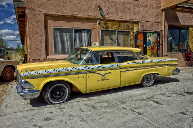 a yellow car parked in front of a building, a colorized photo, by Richard Carline, flickr, photorealism, lowrider style, from better call saul, tail fin, wallpaper - 1 0 2 4