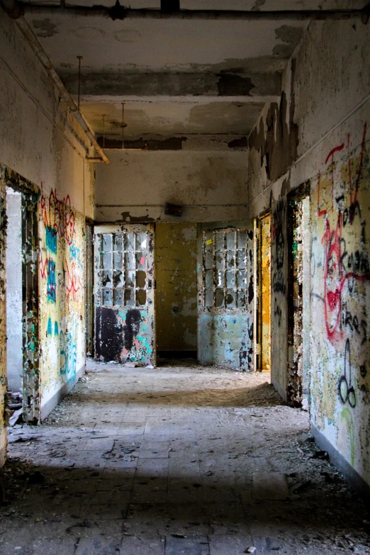 a run down building with graffiti all over the walls, by Emanuel Schongut, flickr, natural prison light, many doorways, prize winning color photo, military buildings