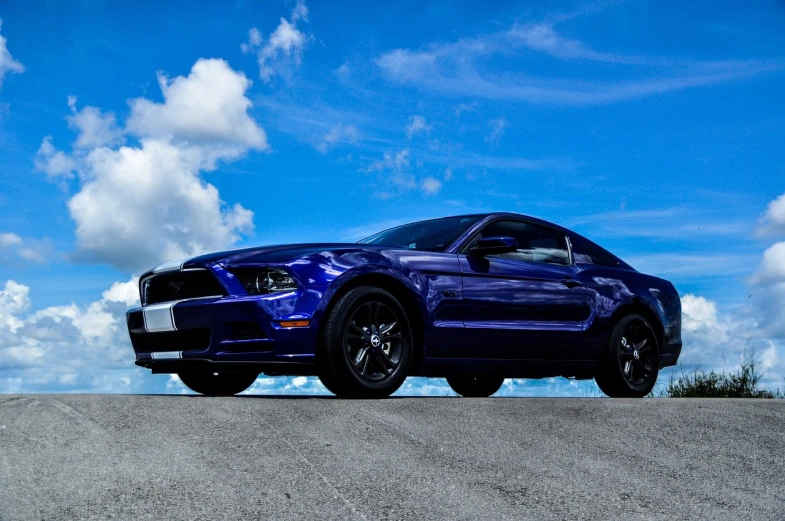 a blue mustang parked on the side of a road, a picture, by Ben Thompson, pexels contest winner, cobra, blue skies, 2013, hurricane, motorsports photography