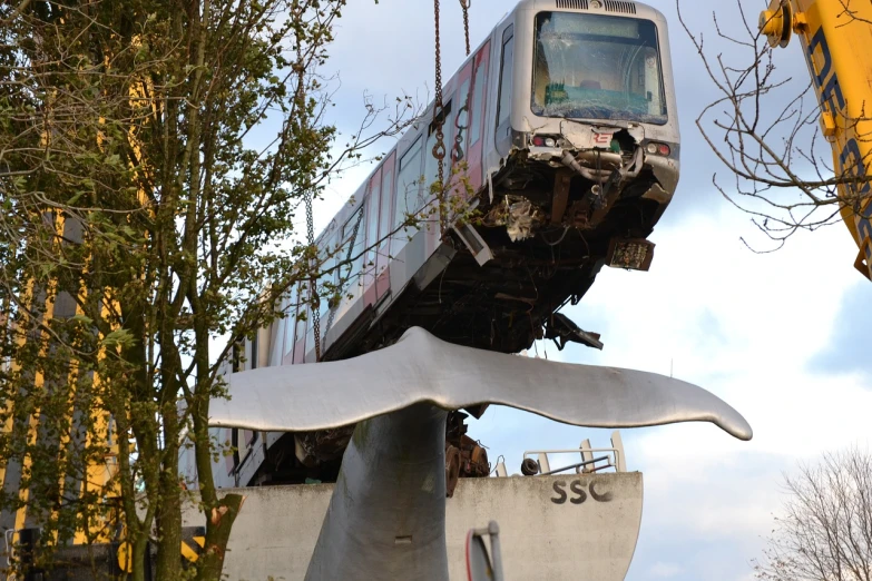 a train that is sitting on top of a piece of metal, by Jens Søndergaard, flickr, happening, flying debris, monorail station, mickael lelièvre, shark