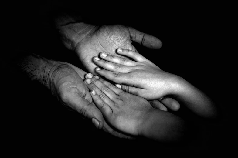 a close up of a person holding a child's hand, a black and white photo, by irakli nadar, art photography, feet and hands, photography of albert watson, tim hildebrant, grandfatherly