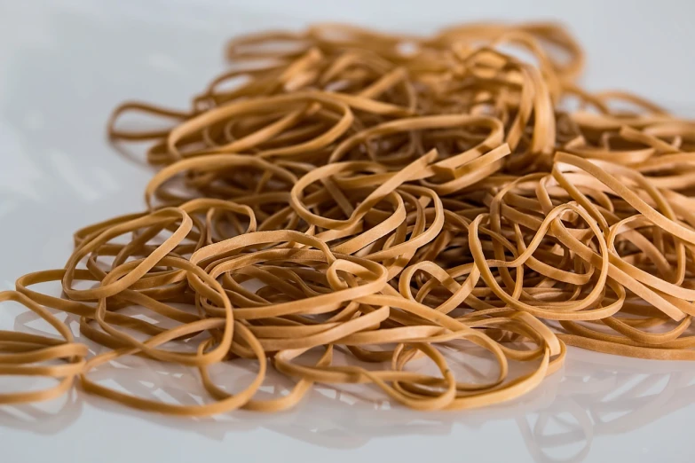 a pile of noodles sitting on top of a white table, a picture, by Josef Navrátil, pexels, plasticien, 50mm close up photography, leathery, hasbulla magomedov, close up to a skinny